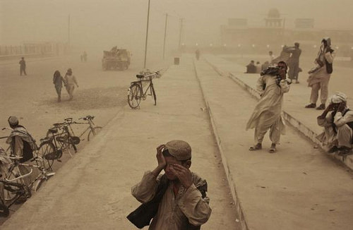A boy covers his eyes during a sandstorm in the southern city of Kandahar ⓒ Moises Saman