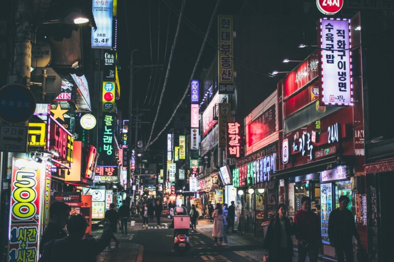 A lively Seoul street at night with neon signs and people walking, capturing the essence of urban life in South Korea.