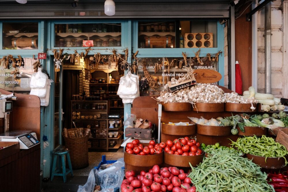 Explore a traditional Turkish market stall showcasing fresh vegetables and hanging spices.